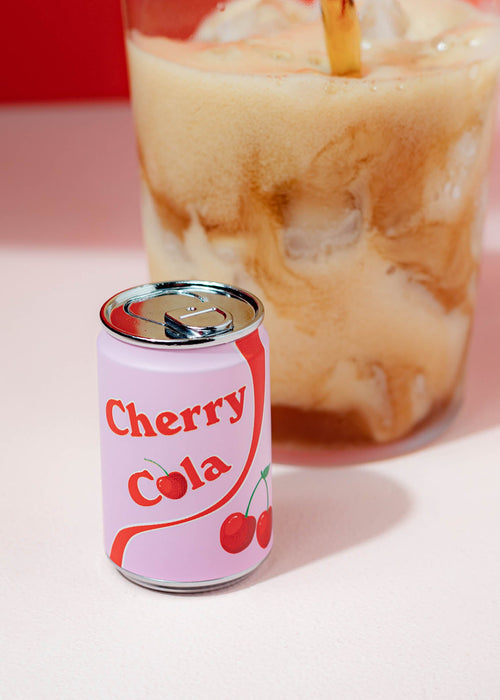 Miss Behavin' Cherry Cola Lighter standing upright beside an iced coffee drink